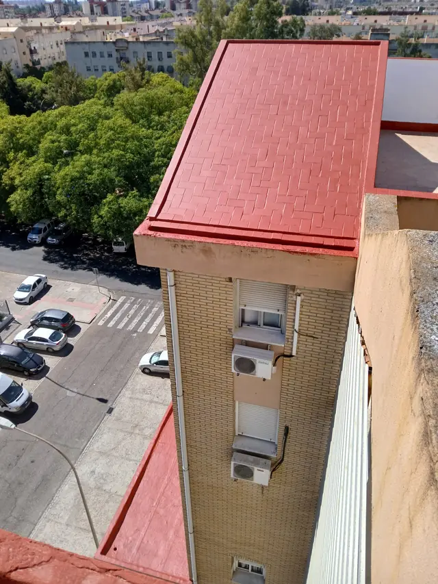 Cubierta de un bloque de viviendas impermeabilizada en rojo