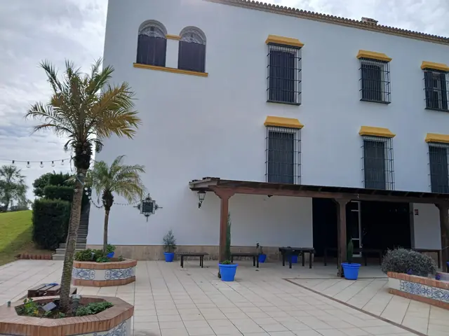 Fachada de cortijo restaurada en blanco y albero