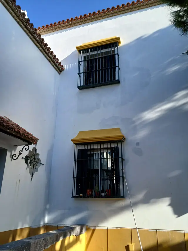 Fachada encalada con recercados de ventanas en albero