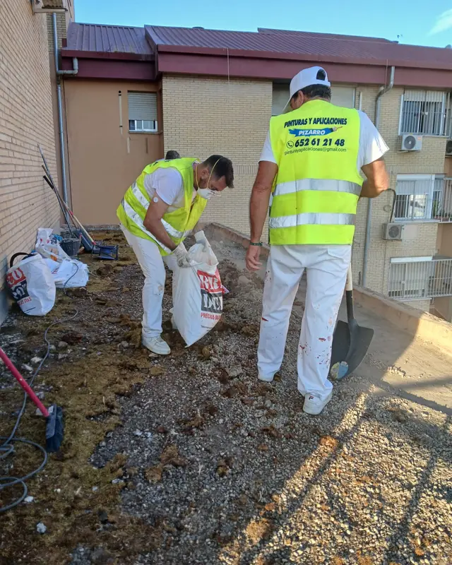 Operarios retirando la grava de una azotea