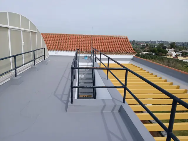 Terraza transitable impermeabilizada en gris junto a tejado