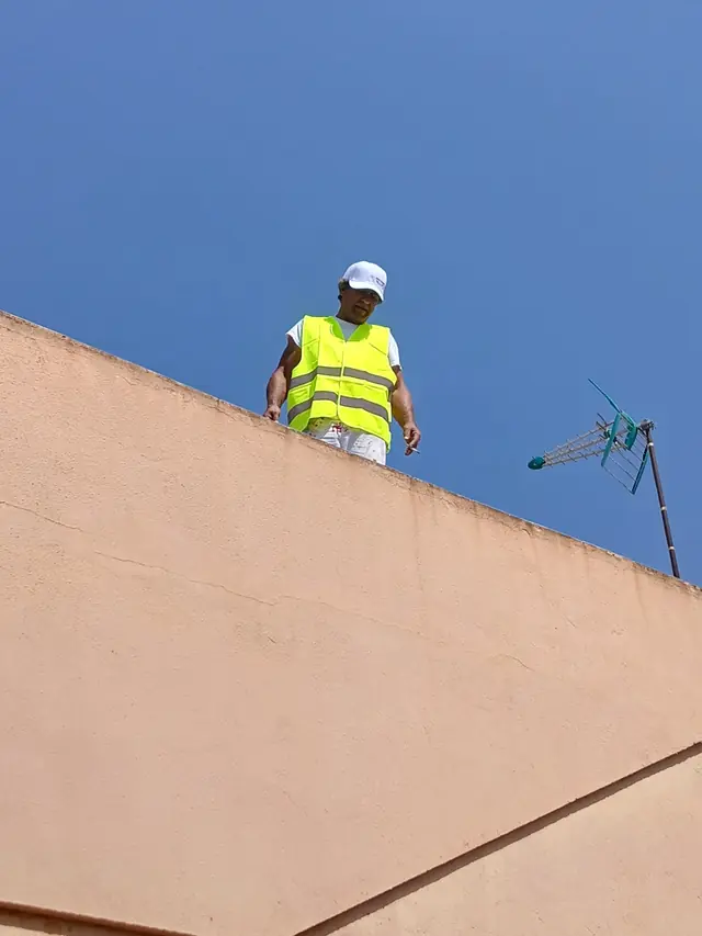 Operario revisando la cornisa de una fachada